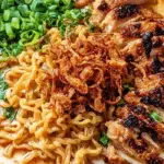Fiery Chicken Ramen with Creamy Garlic Sauce topped with grilled chicken, scallions, and crispy onions