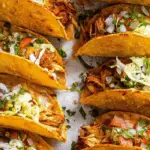 Mini Baked Chicken Tacos served on a rustic wooden tray