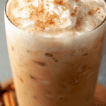 iced pumpkin cream chai tea latte in glass with pumpkin foam