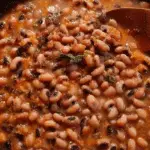 Cajun blackeyed peas served in cast iron pot with cornbread