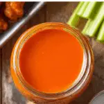 Buffalo Wing Sauce in jar with wings and dips