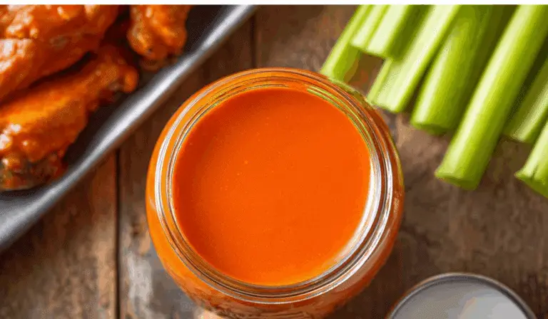 Buffalo Wing Sauce in jar with wings and dips