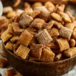 Churro Chex Mix in bowl with cinnamon sticks